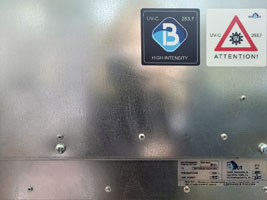 Фото заводского шильдика с номером № 107, а также информационных и предупреждающих наклеек об UV-C-излучении на корпусе бактерицидной секции Vent Bact VB 900